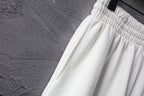 White shorts with ribbed elastic waistband and stitched pleats