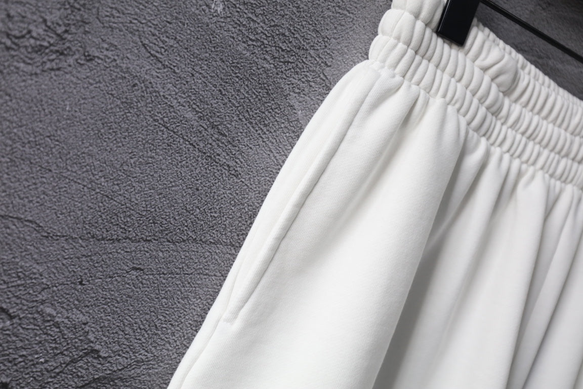 White shorts with ribbed elastic waistband and pleated leg.