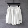 White Balenciaga shorts with elastic waistband and small black logo on leg