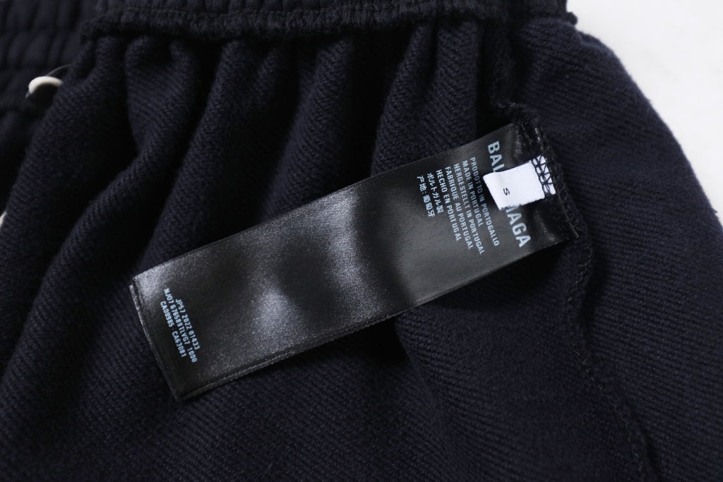 Dark Balenciaga pants with brand and care tags on waistband area