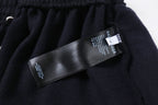 Dark Balenciaga pants with brand and care tags on waistband area