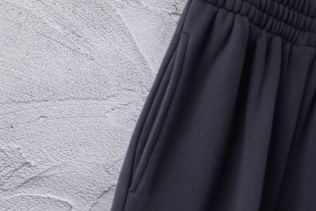 Dark Balenciaga pants fabric with subtle texture and pleated drape
