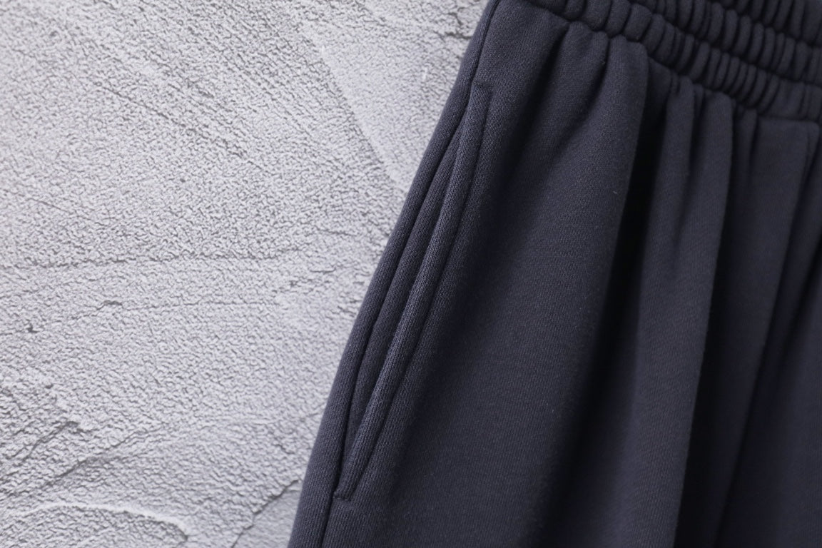 Dark Balenciaga pants fabric with subtle texture and pleated drape