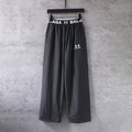 Black wide-leg pants with elastic waistband and Balenciaga logo at front