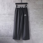 Black wide-leg pants with elastic waistband and Balenciaga logo at front