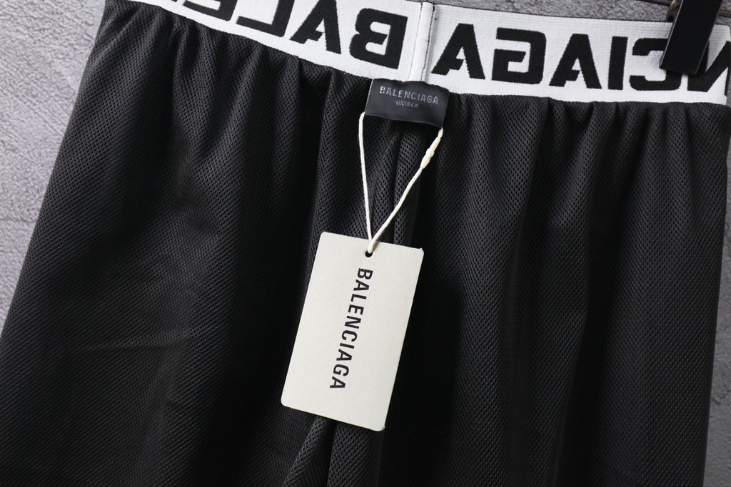 Black pants with textured fabric and hang tag at elastic waistband