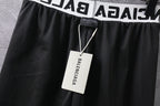 Black pants with textured fabric and hang tag at elastic waistband