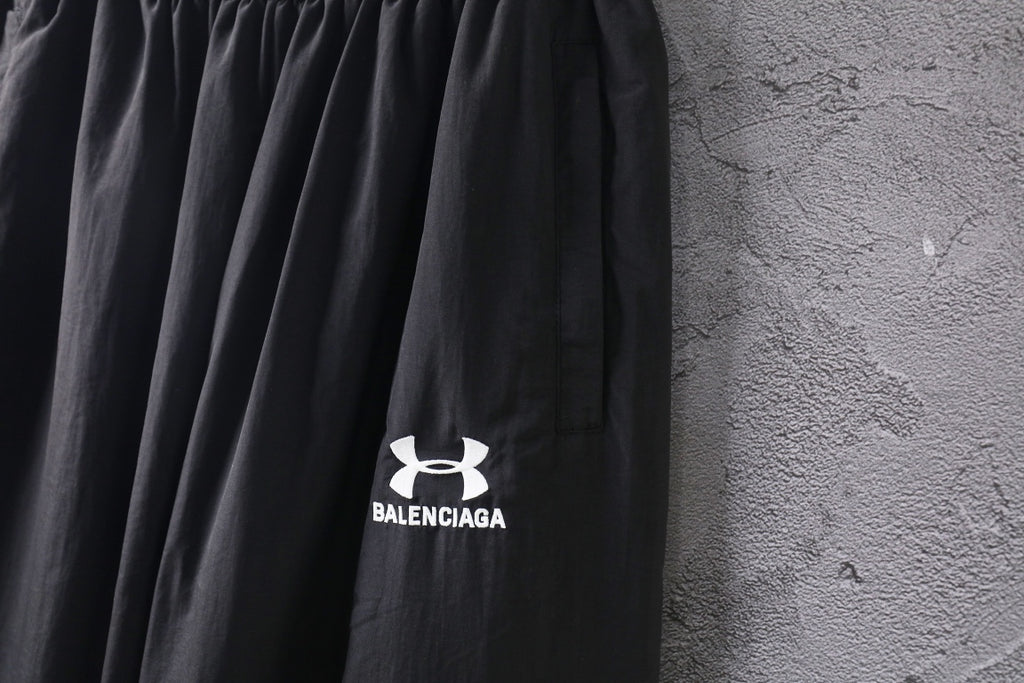 Black wide-leg pants with front Under Armour and Balenciaga logo prints