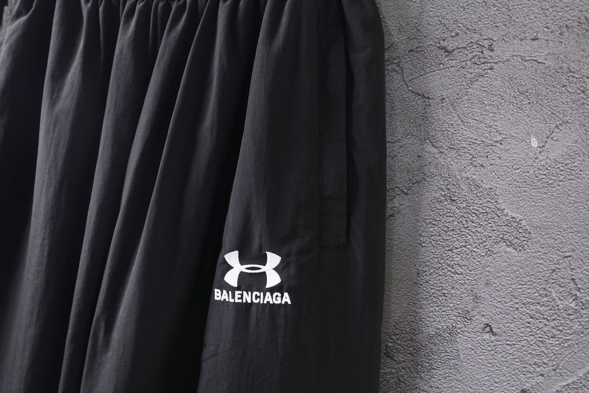 Black wide-leg pants with front Under Armour and Balenciaga logo prints