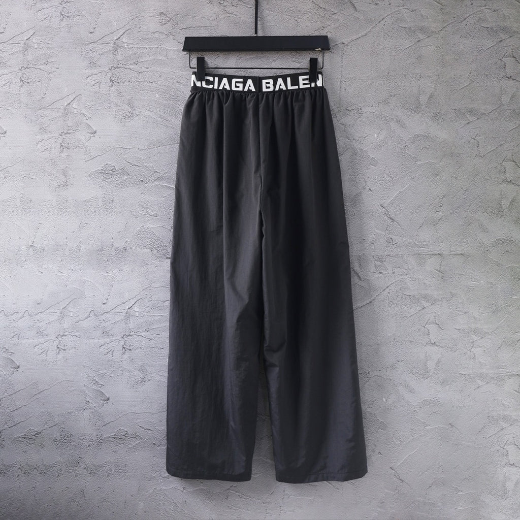 Black wide-leg pants with elastic waistband and large Balenciaga text logo
