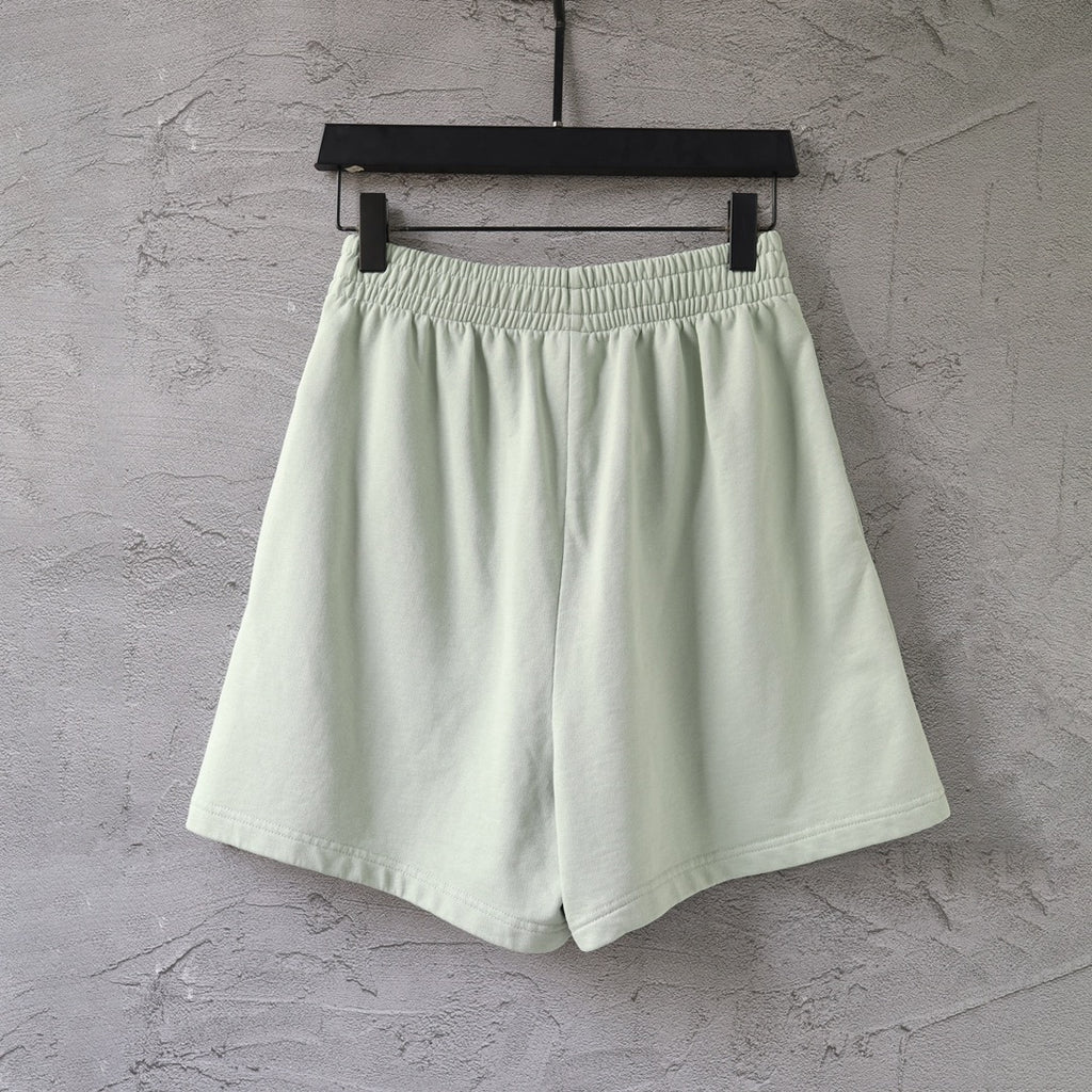 Light-green shorts on hanger with elastic waistband and wide-leg silhouette