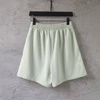 Light-green shorts on hanger with elastic waistband and wide-leg silhouette