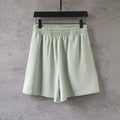 Balenciaga light green smocked waist shorts with relaxed fit and pleated front