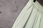 Light-green shorts with elastic cuff hem and seam detail on the leg