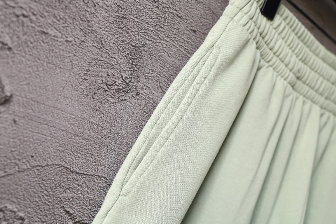 Light-green shorts with elastic cuff hem and seam detail on the leg