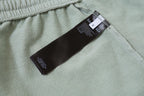 Light-green shorts with inner care tag near elastic waistband