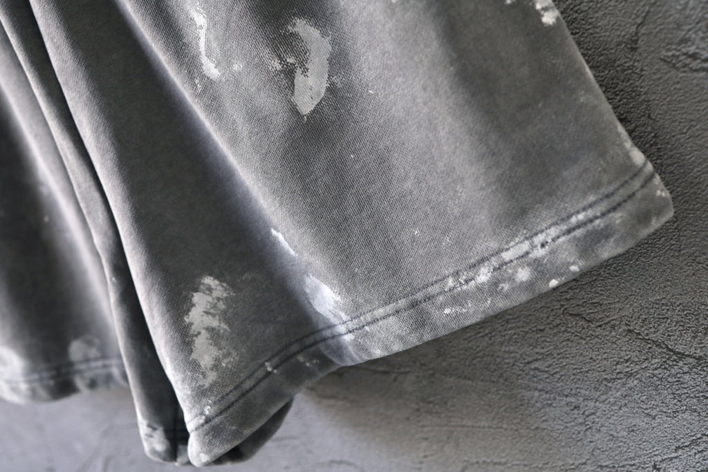 Distressed hem and stitched seam on light gray shorts