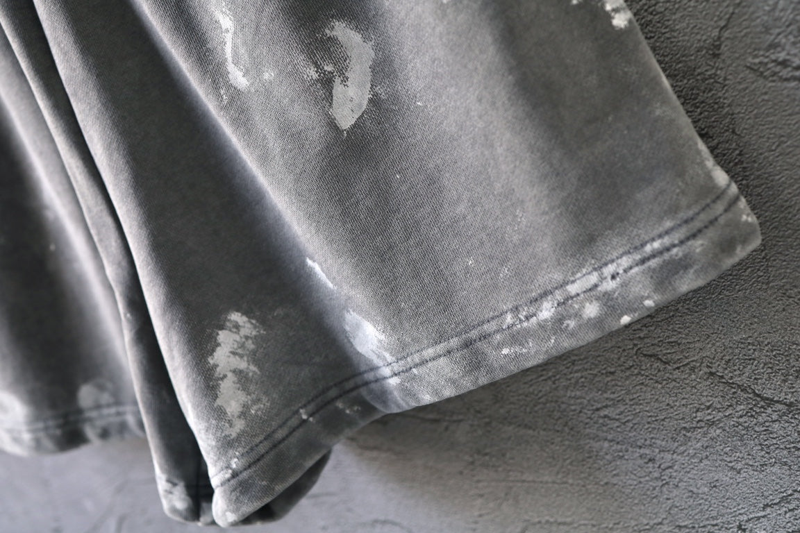 Distressed hem and stitched seam on light gray shorts