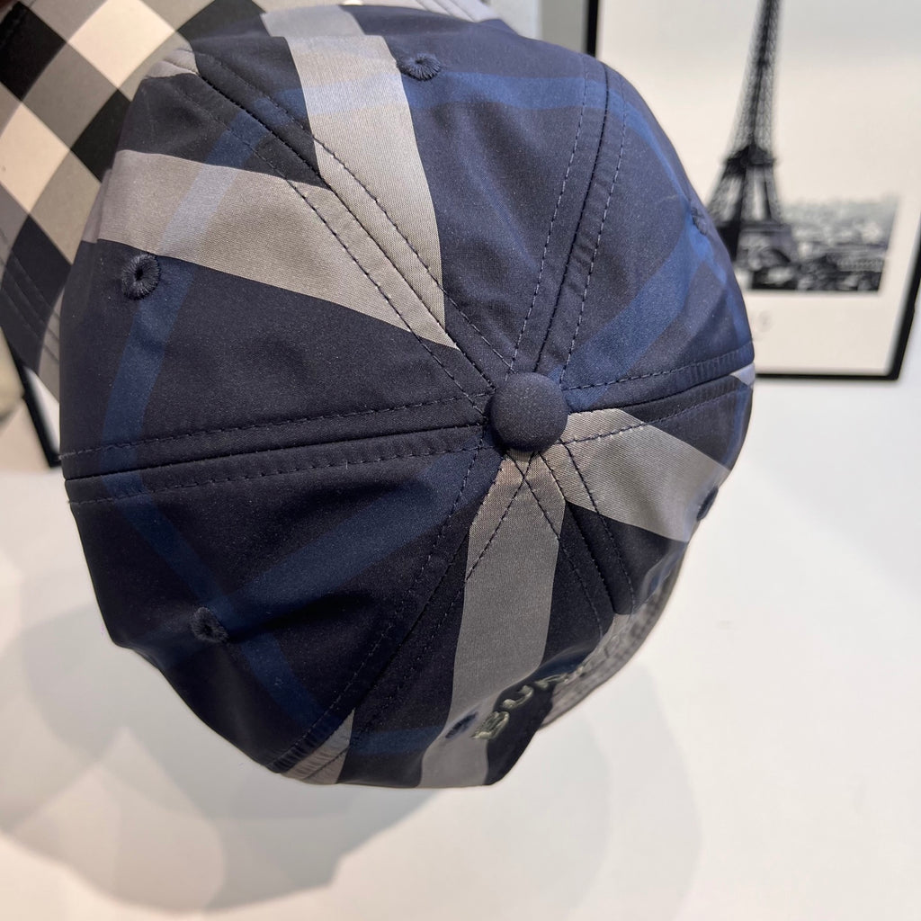 Navy plaid baseball cap with a small button at the crown and stitched panels