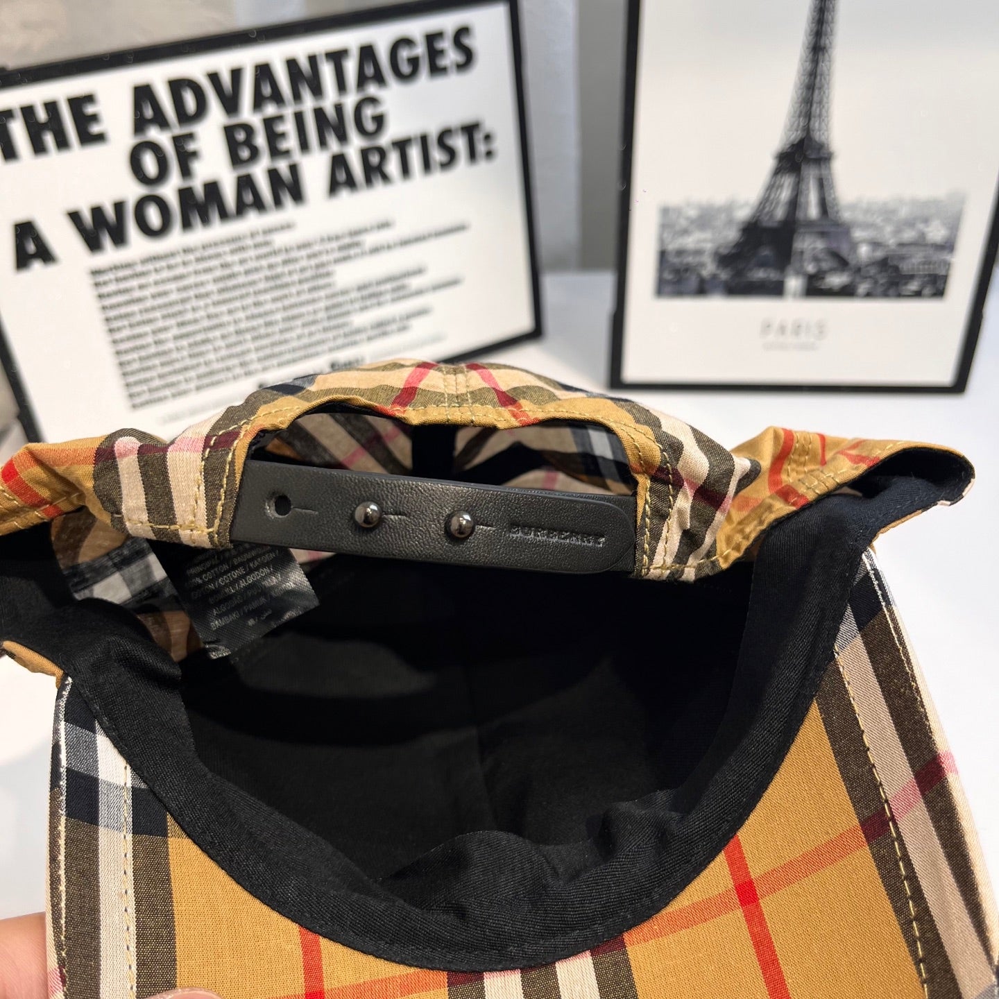 Plaid cap interior with black lining and leather-style adjustable strap
