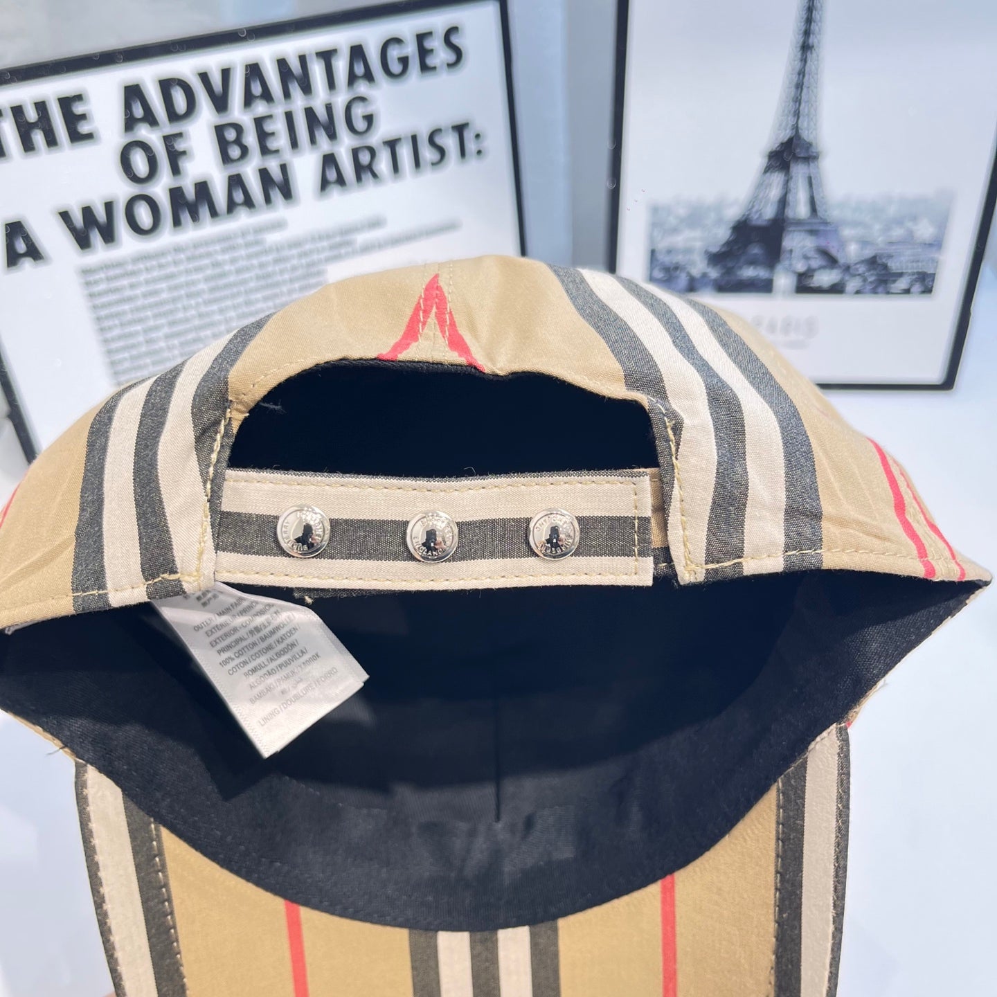 Striped baseball cap interior panel with three metal studs