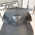 Prada baseball cap in dark gray fabric with embroidered triangular logo patch on crown