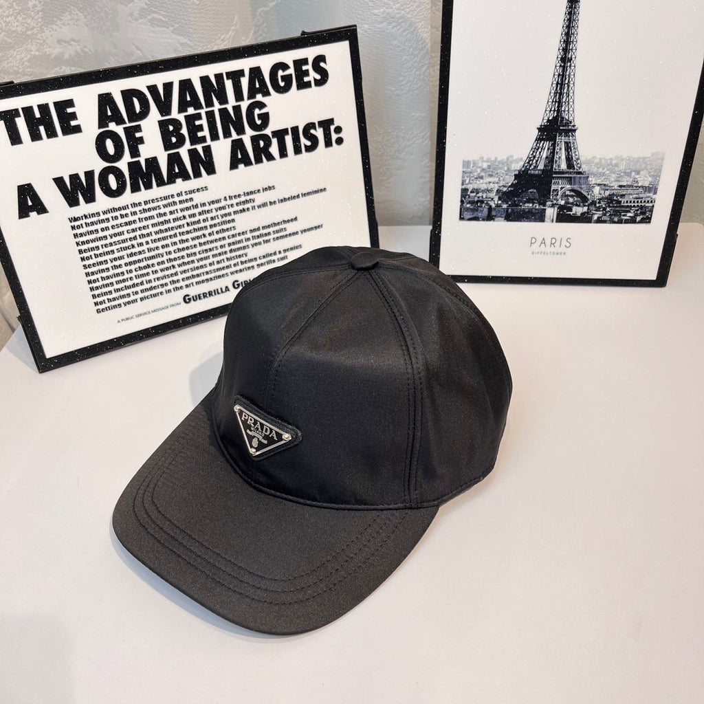 Prada baseball cap, side view, dark fabric with embroidered triangular logo badge