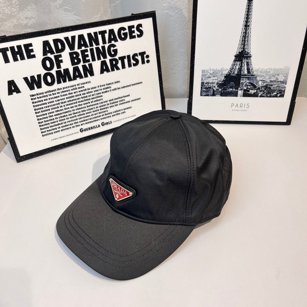 Prada cap with triangular logo patch on dark fabric, side view.