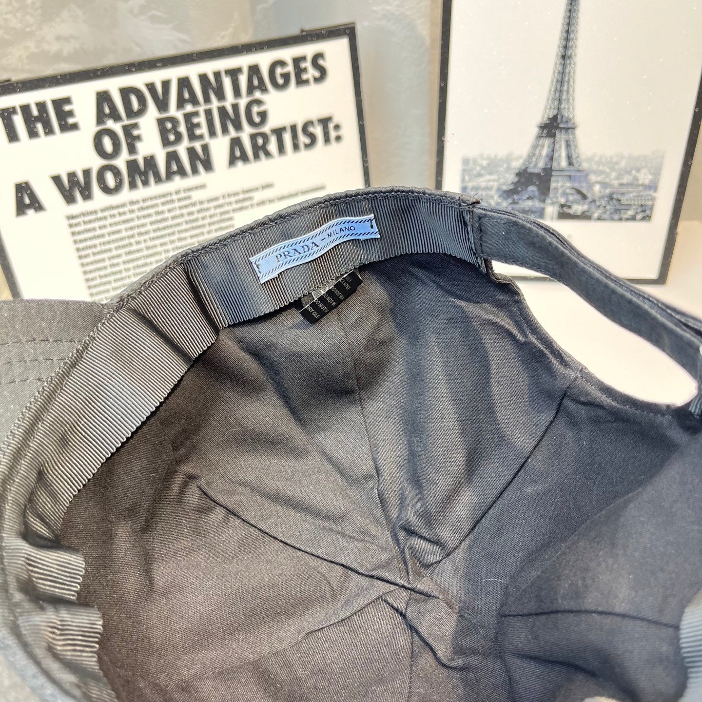 Prada cap interior with fabric strap and small branded label near opening.