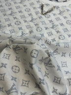 Light monogram T-shirt fabric close-up showing navy and gray motifs
