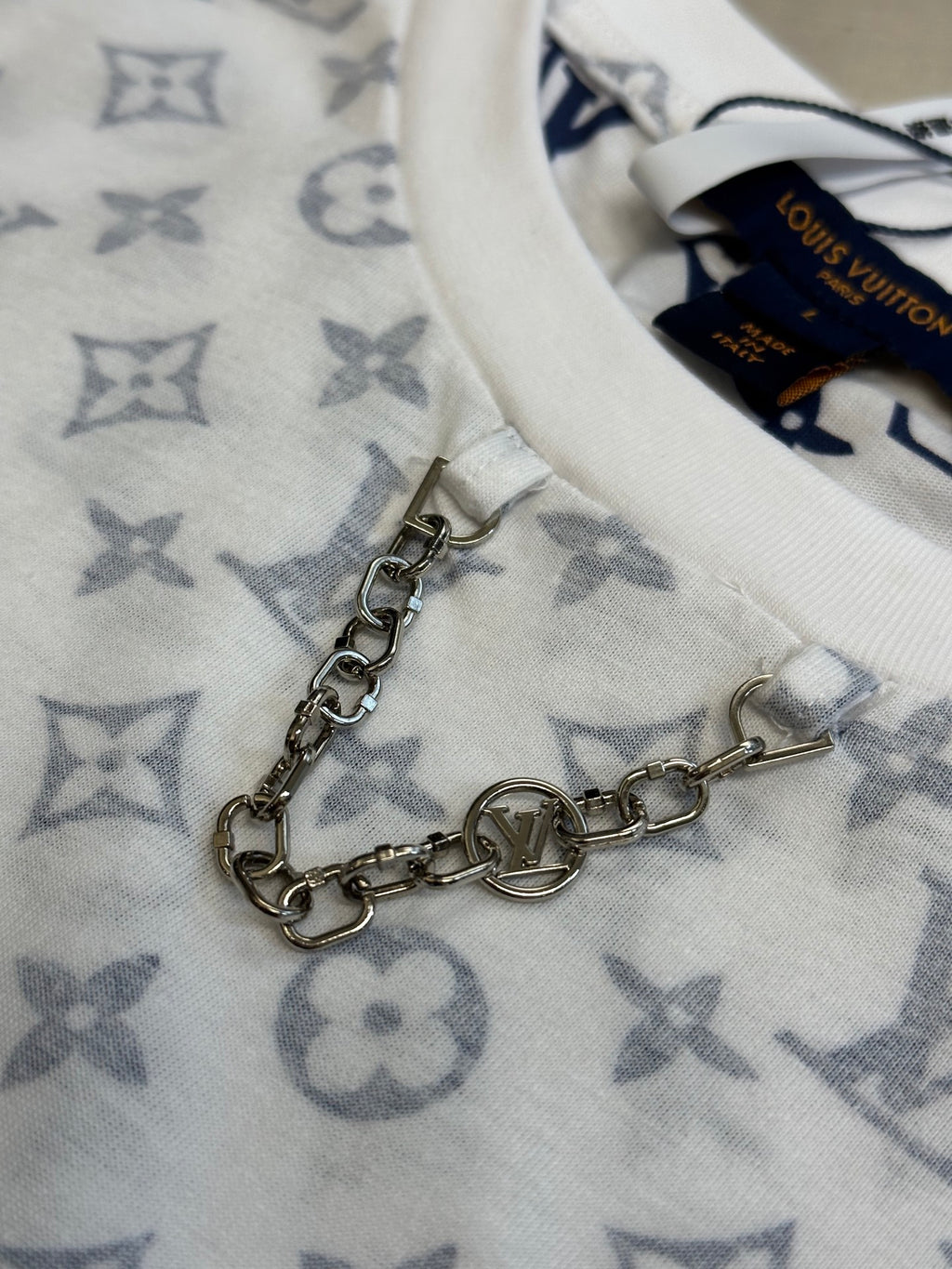 Metal chain accessory on light monogram T-shirt fabric