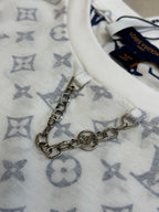 Metal chain accessory on light monogram T-shirt fabric