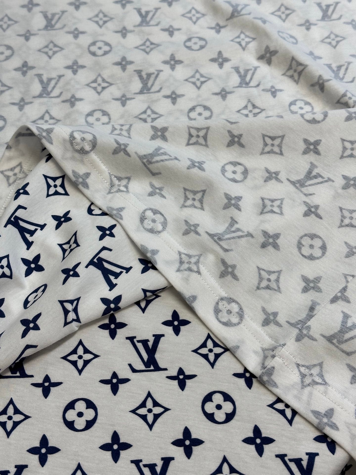 Light monogram T-shirt fabric close-up with navy and gray allover print