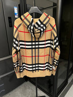 Beige plaid zip-front hoodie with black check stripes and red accents on sleeves
