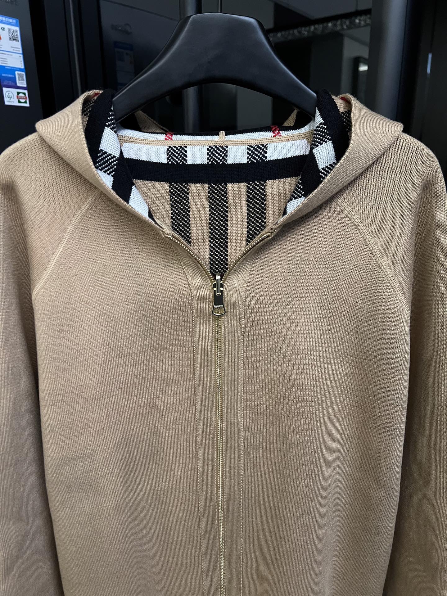 Beige zip-front sweatshirt with stand collar and black-and-white striped inner neck facing