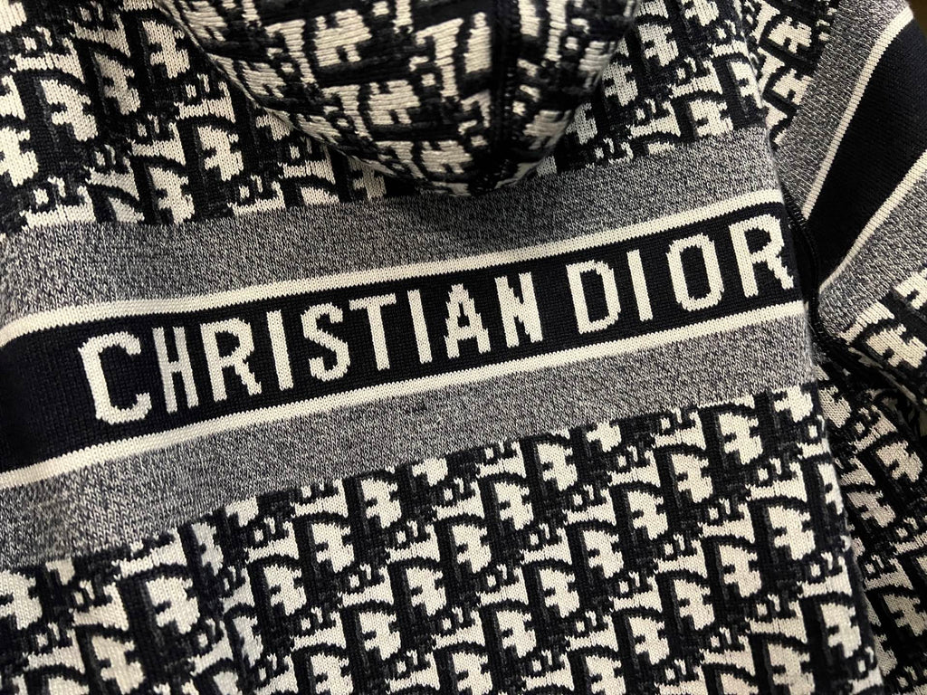 Dior hooded zip jacket close-up of "CHRISTIAN DIOR" logo stripe and knit texture