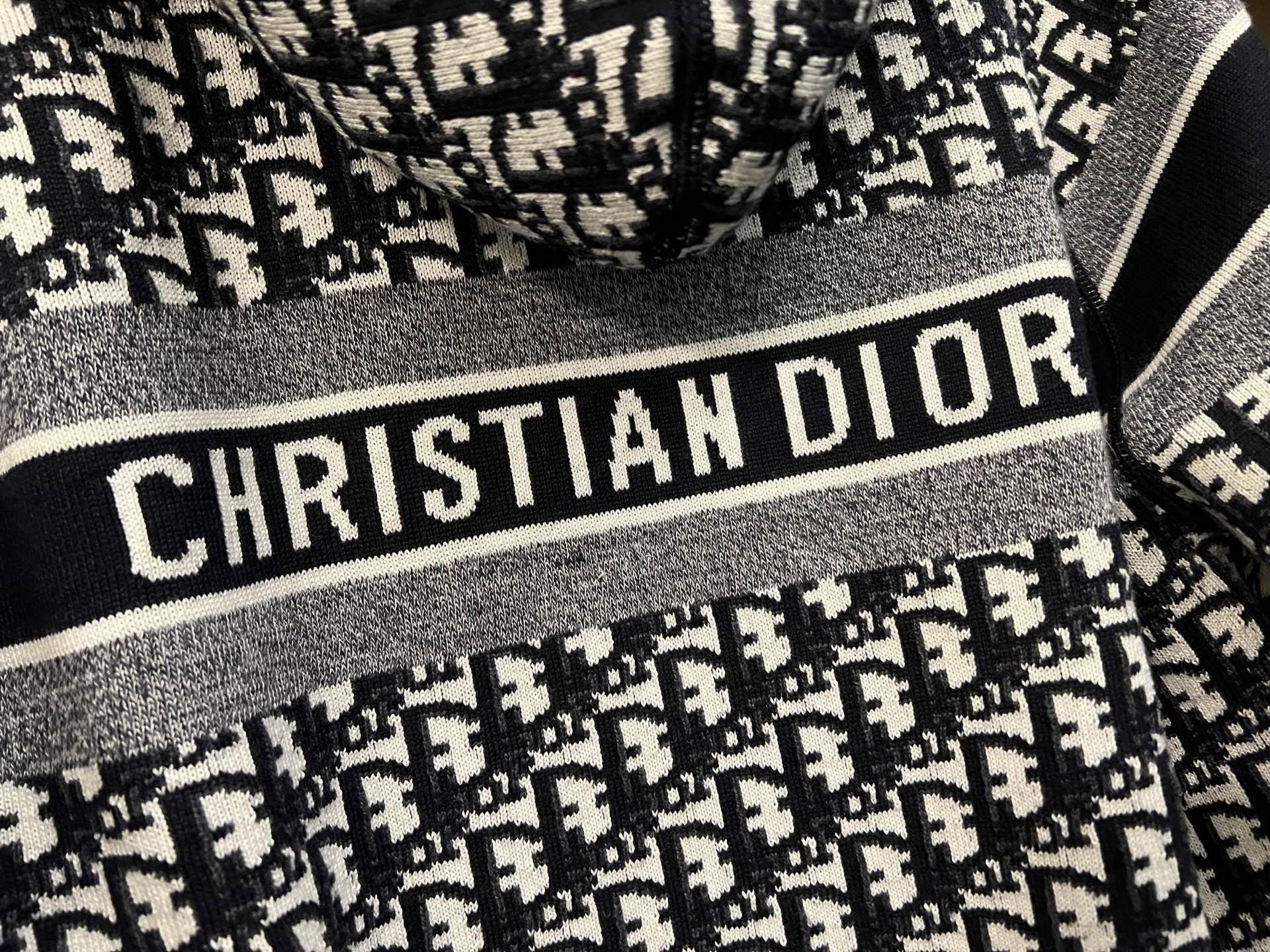 Dior hooded zip jacket close-up of "CHRISTIAN DIOR" logo stripe and knit texture