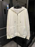 Off-white zip-up hoodie with hood, drawstring ties, and front kangaroo pockets.