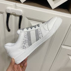 White Gucci unisex sneakers held up with gray stripe side panel and lace-up top