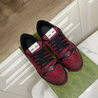 Gucci unisex sneakers top view, burgundy uppers with black laces and web-style strap detail