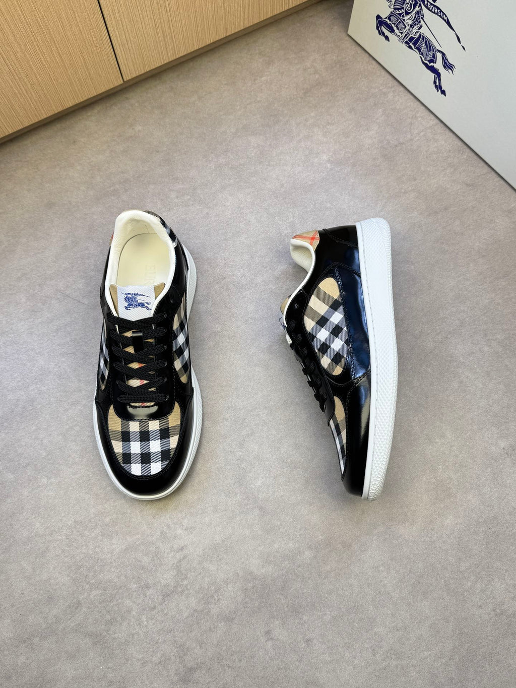Black and white checkered sneakers, side view with blue logo detail and white sole