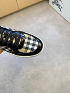 Black leather-and-check sneakers, close side view showing black laces and trim