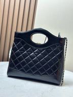 Black quilted handbag with oval cutout handle and gold-tone chain strap