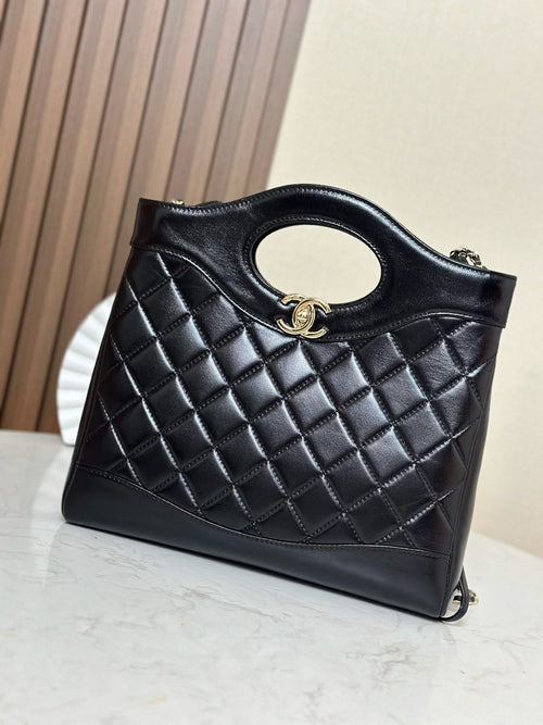 Black quilted handbag with oval cutout handle, gold-tone clasp and chain strap