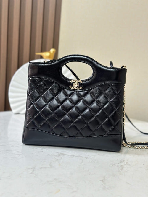 Chanel black quilted handbag with oval logo top handle and gold-tone chain strap
