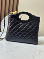 Black quilted handbag with oval logo ring top handle and gold-tone chain strap
