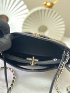 Black handbag interior view with top zipper and gold-tone bar clasp hardware