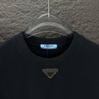 Prada black crewneck T-shirt with gold triangle logo, front neckline close-up
