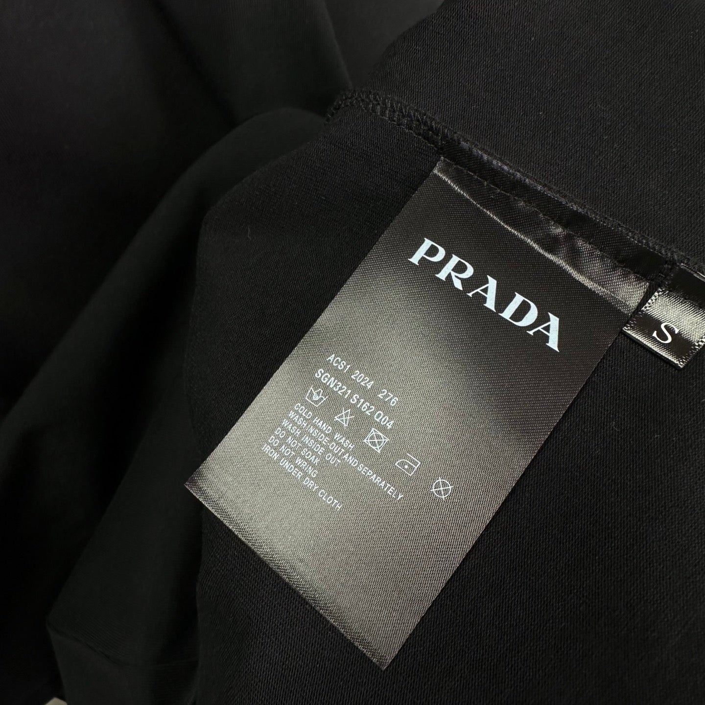 Prada black T-shirt care tag and size label near collar