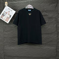 Prada black short-sleeve T-shirt with small gold triangle logo at chest